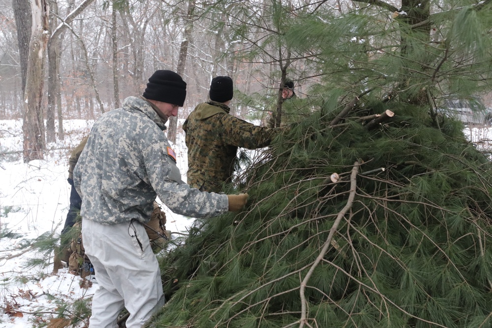 Cold-Weather Operations Course students build improvised shelters, survive outdoors