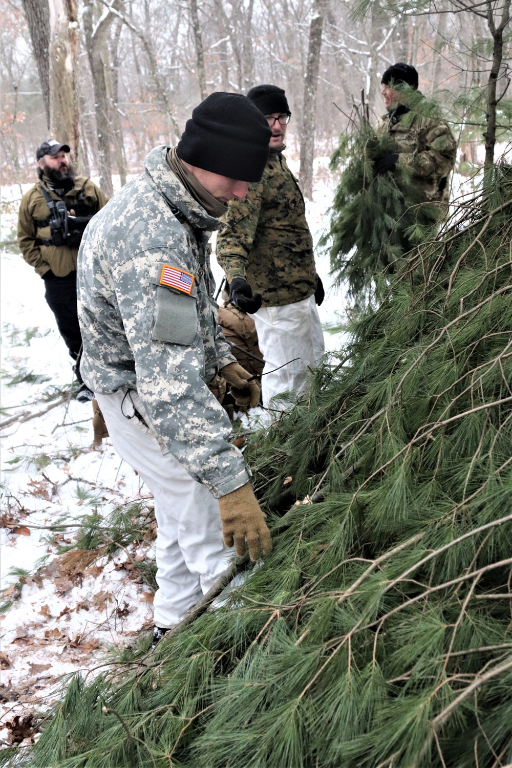 Cold-Weather Operations Course students build improvised shelters, survive outdoors