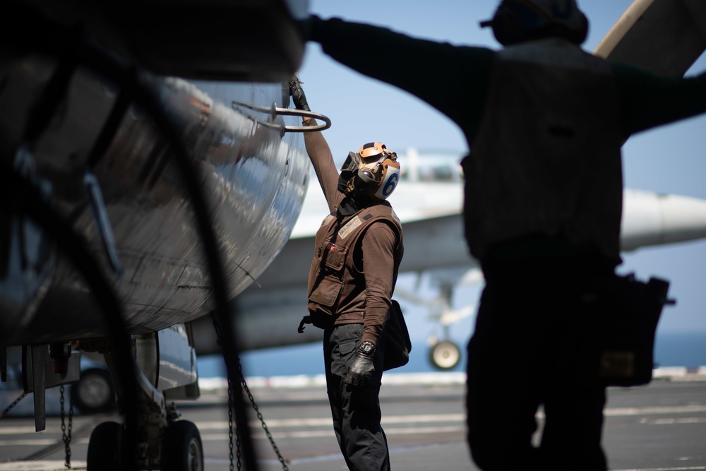 U.S. Sailor cleans an E-2C Hawkeye during flight operations