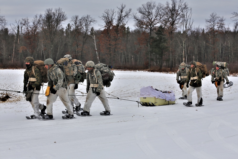 Fort McCoy Cold-Weather Operations Course students train in snowshoes pulling ahkio sled