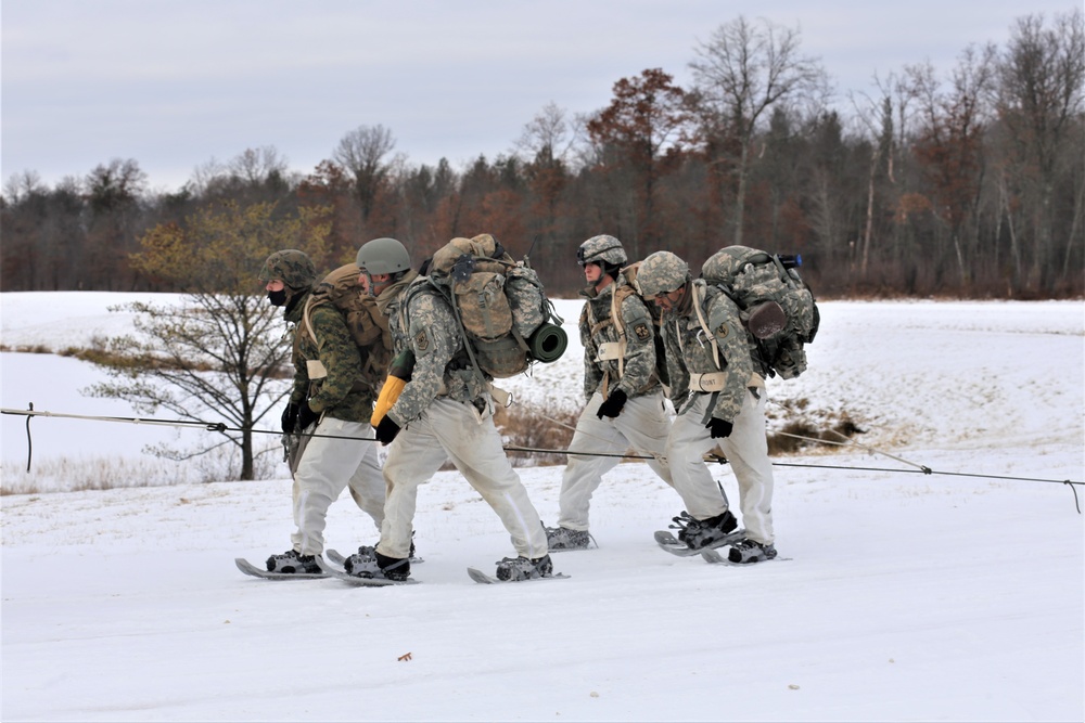 Fort McCoy Cold-Weather Operations Course students train in snowshoes pulling ahkio sled