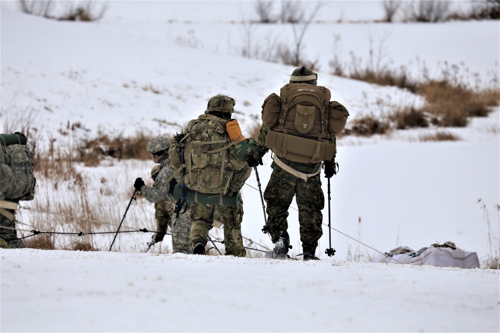 Fort McCoy Cold-Weather Operations Course students train in snowshoes pulling ahkio sled