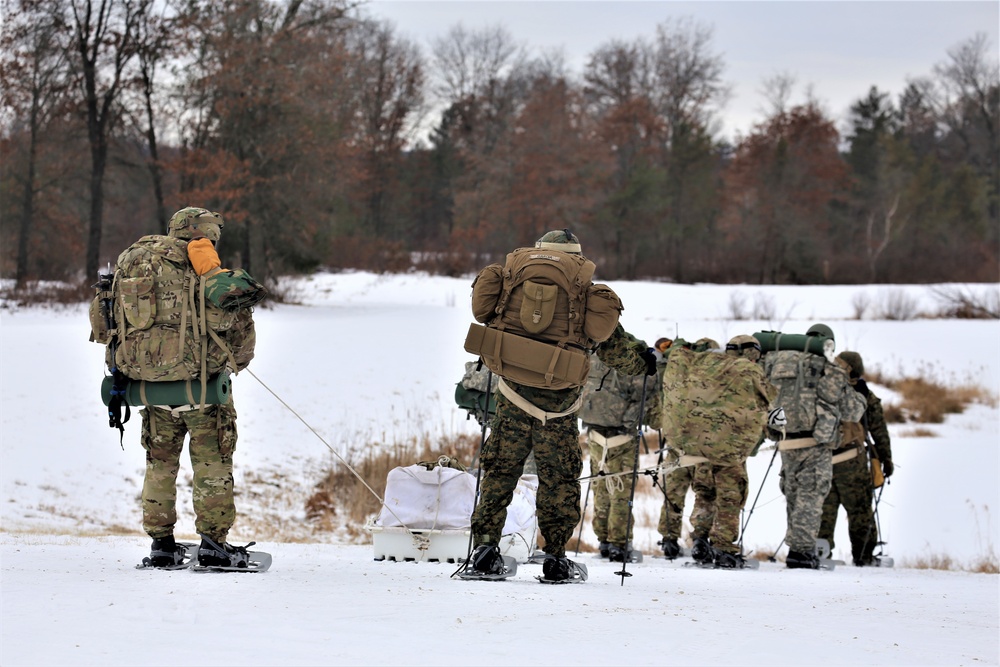 Fort McCoy Cold-Weather Operations Course students train in snowshoes pulling ahkio sled