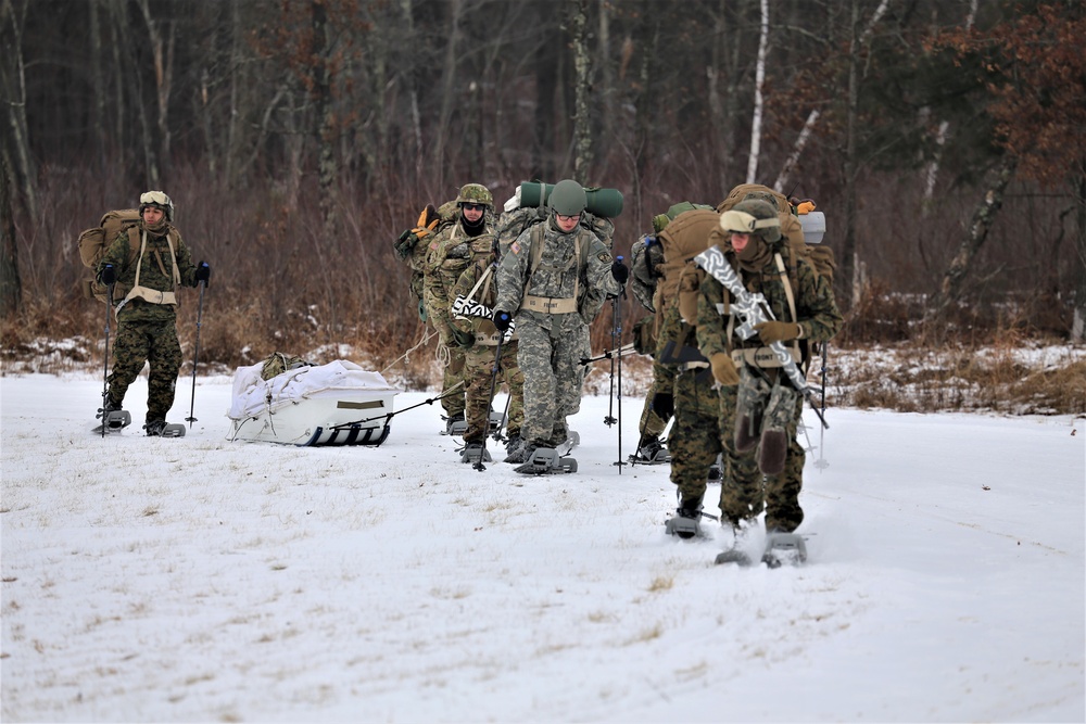 Fort McCoy Cold-Weather Operations Course students train in snowshoes pulling ahkio sled