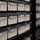 The image shows a wall of organized component storage drawers labeled with Jameco Electronics branding. The drawers contain electronic components including CD4000 Integrated Circuits and LEDs &amp; Mounting Hardware, each with catalog labels showing series, location, and part numbers. The photo is taken at an angle with depth-of-field blur affecting the peripheral drawers.