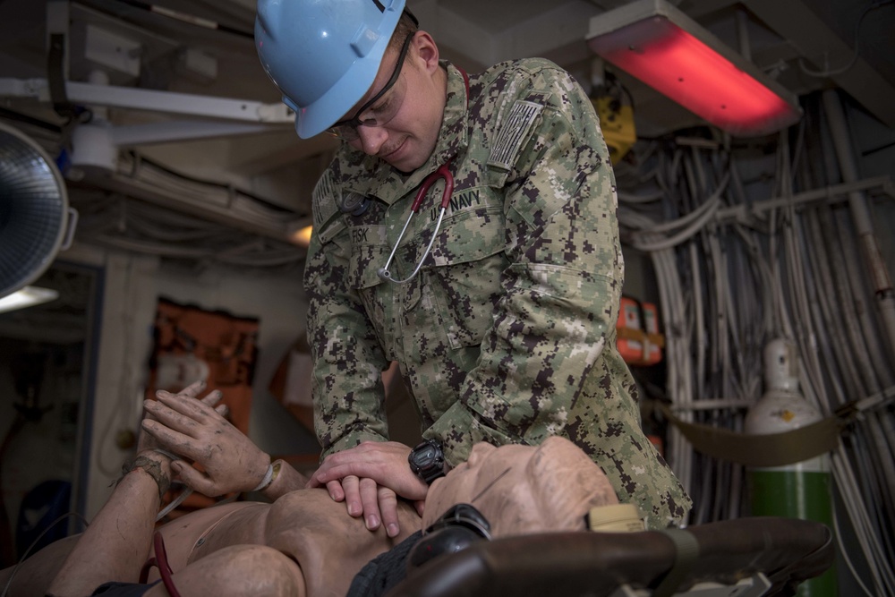 USS Carl Vinson Sailor practices CPR on a medical mannequin