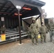 TF MED Soldiers gather under a hut