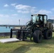 U.S. Navy Seabees replace sidewalks and repair a seawall on board Naval Base White Beach