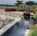 U.S. Navy Seabees replace sidewalks and repair a seawall on board Naval Base White Beach