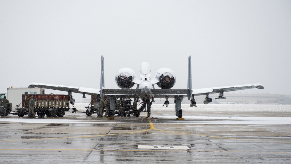 Snow covered Airmen work on A-10 Thunderbolt II