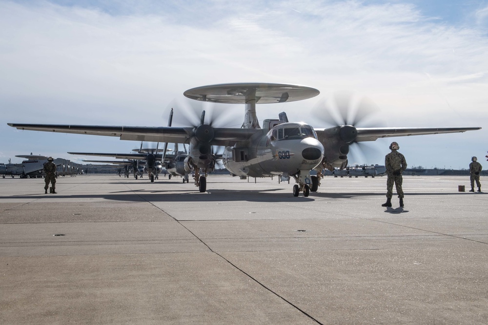 E-2D Hawkeyes fly in formation over an airfield in Norfolk