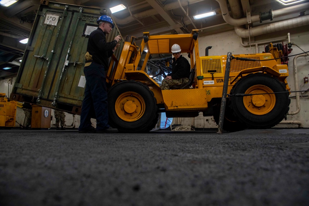 Sailors move cargo in the well deck of New York