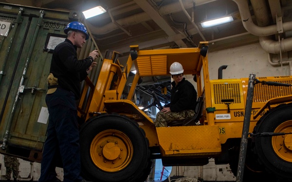 Sailors move cargo in the well deck of New York