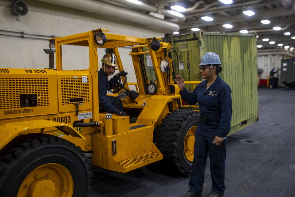 Sailors move cargo in the well deck of New York.