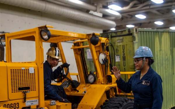 Sailors move cargo in the well deck of New York.