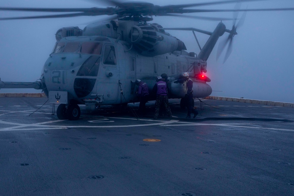 Sailors refuel a CH-53E on the flight deck of the New York