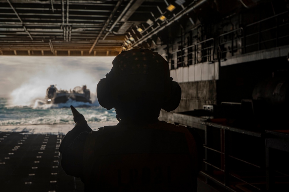 Sailor directs a LCAC in the New York well deck