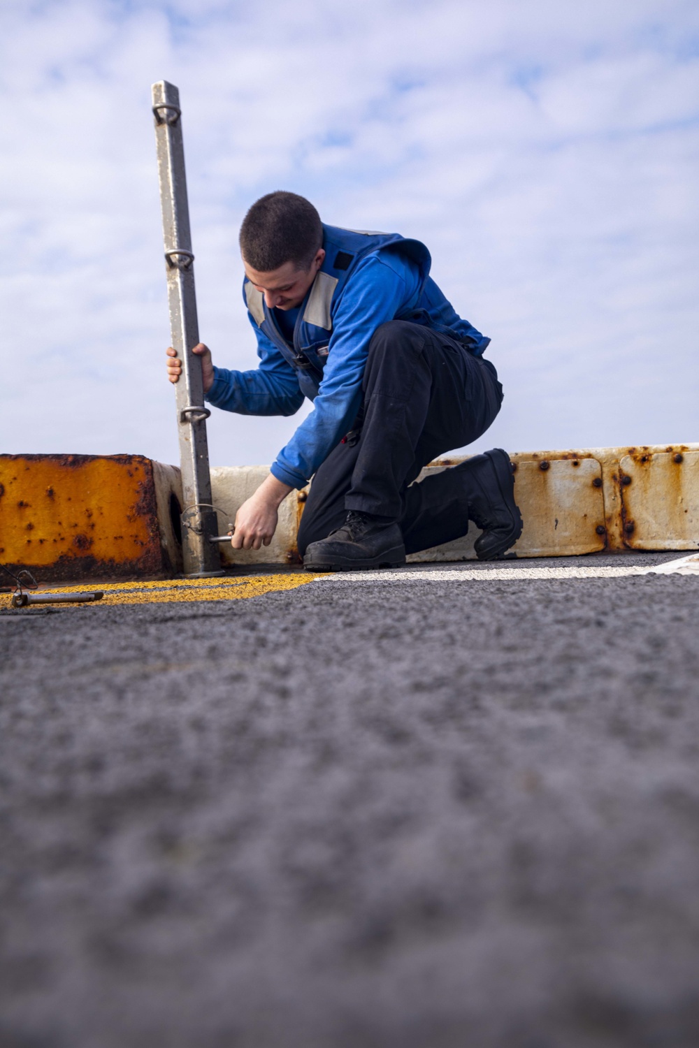 Sailor removes pole in preparation for flight operations