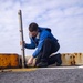 Sailor removes pole in preparation for flight operations