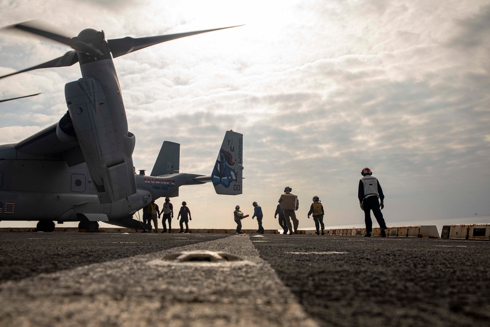 Sailors and Marines move supplies