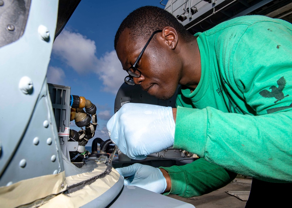 USS Normandy Applies Sealing Compound on MH-60R Sea Hawk Helicopter