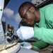 USS Normandy Applies Sealing Compound on MH-60R Sea Hawk Helicopter