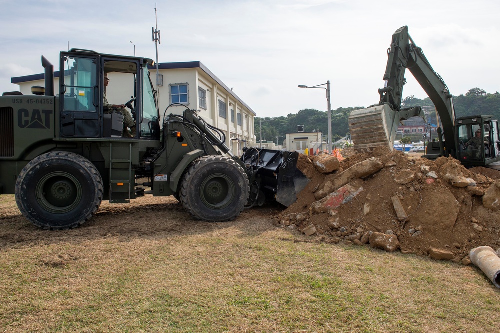 U.S. Navy Seabees repair a seawall on board Naval Base White Beach