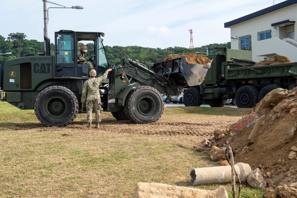 U.S. Navy Seabees repair a seawall on board Naval Base White Beach