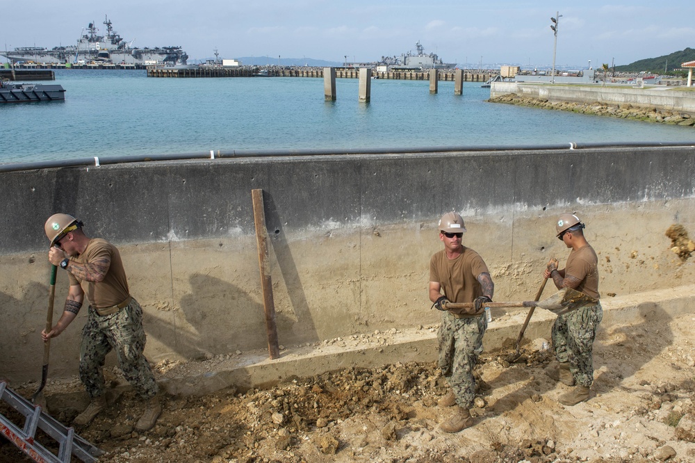 U.S. Navy Seabees repair a seawall on board Naval Base White Beach