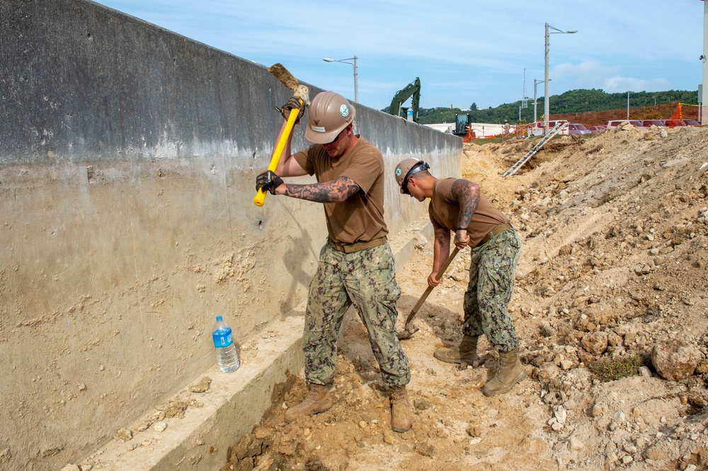 U.S. Navy Seabees repair a seawall on board Naval Base White Beach