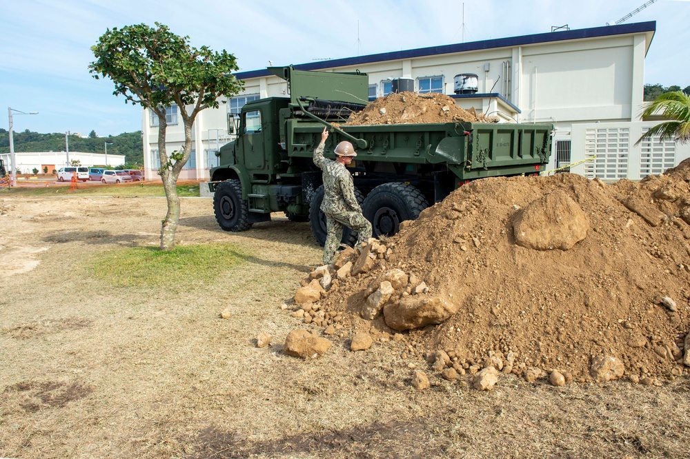 U.S. Navy Seabees repair a seawall on board Naval Base White Beach