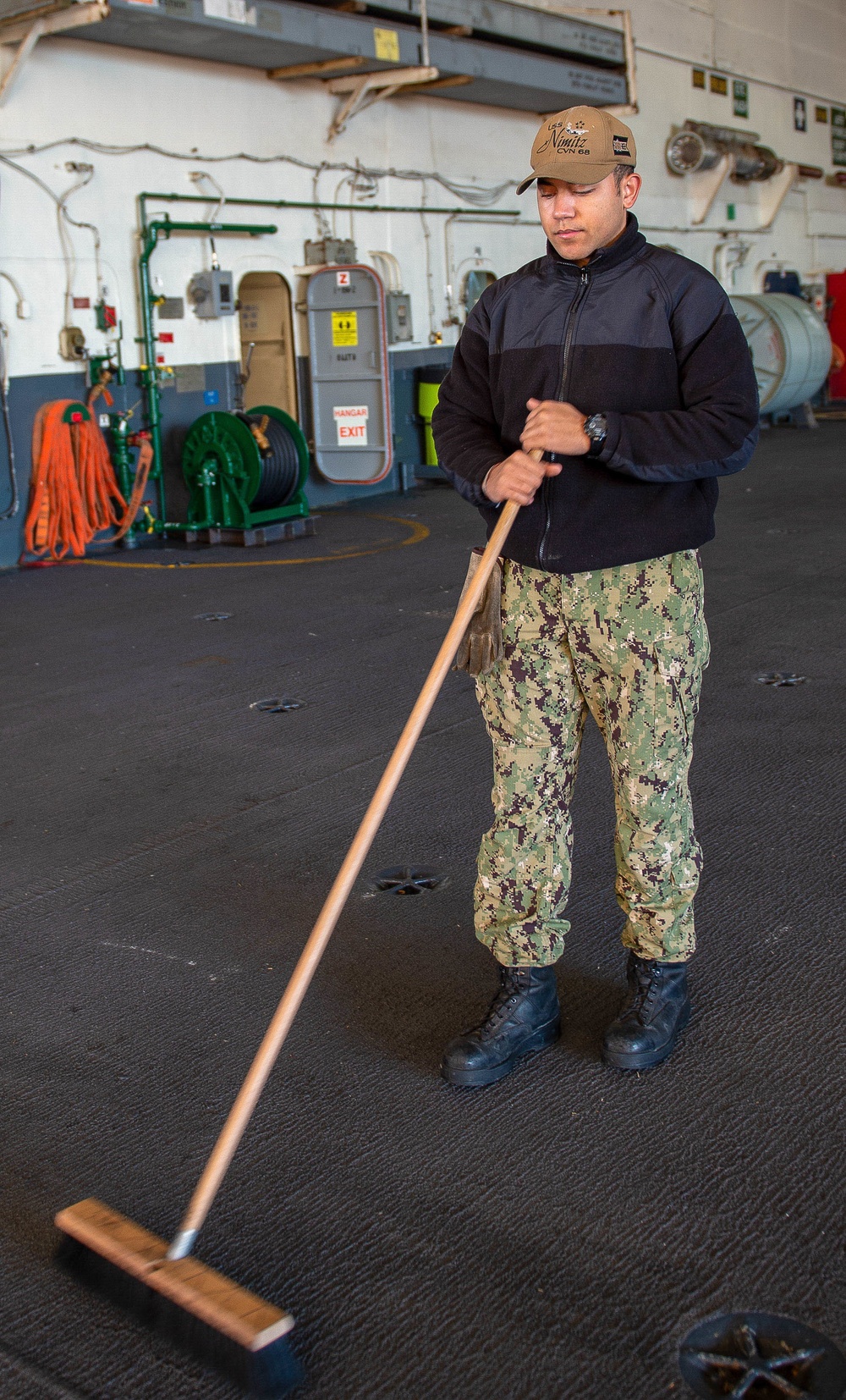 A Sailor Sweeps During Cleaning Stations