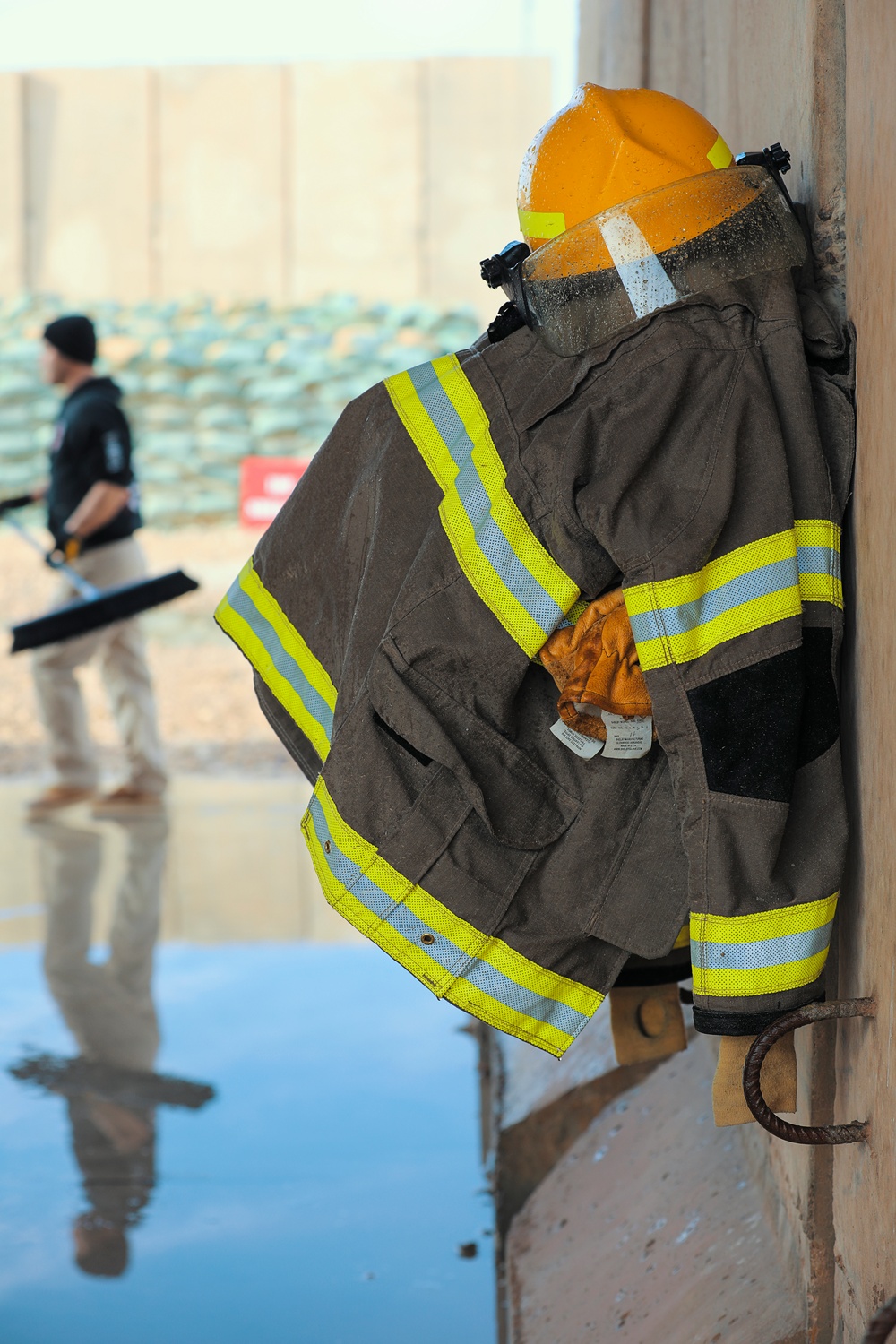 Civilian contractors clean fire truck bays