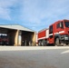 Civilian contractors clean fire truck bays