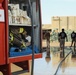 Civilian contractors clean fire truck bays