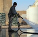 Civilian contractors clean fire truck bays