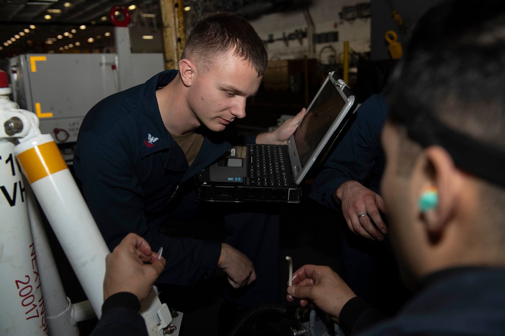 Nimitz sailors do maintenence in hangar bay