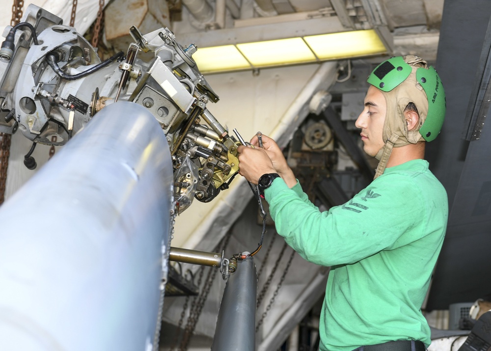 USS Normandy Sailor Performs Maintenance On MH-60R Sea Hawk Helicopter