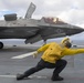 Aviation Boatswain's Mates signal aircraft to take off of the flight deck of amphibious assault ship USS America (LHA 6)