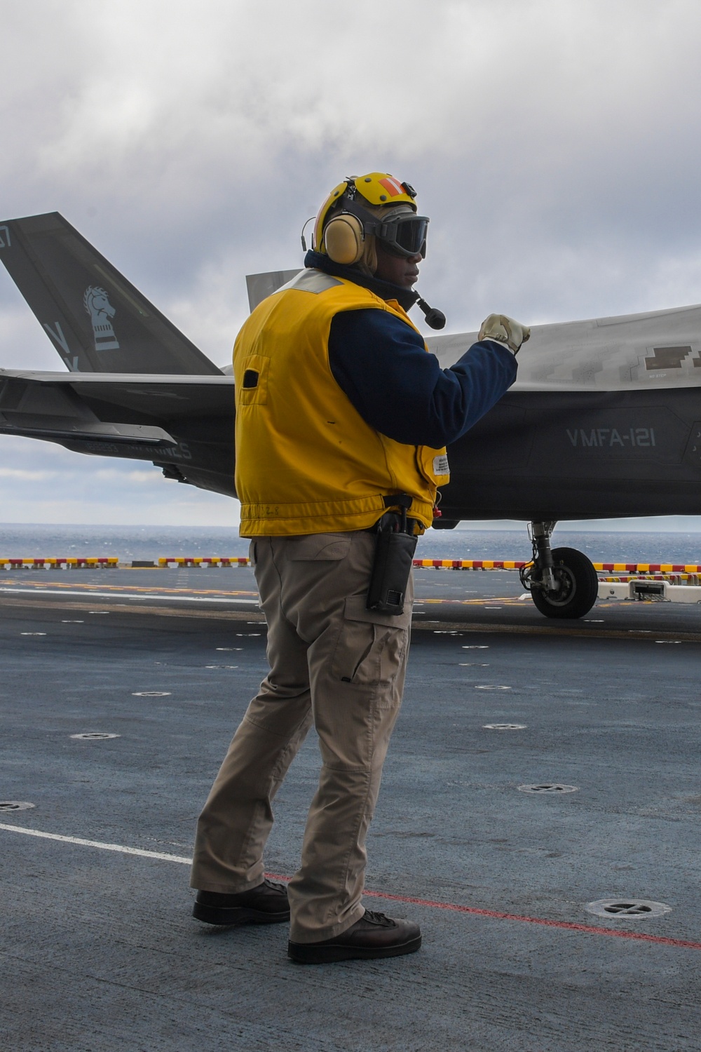 Aviation Boatswain's Mates signal aircraft to take off of the flight deck of amphibious assault ship USS America (LHA 6)