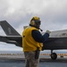 Aviation Boatswain's Mates signal aircraft to take off of the flight deck of amphibious assault ship USS America (LHA 6)