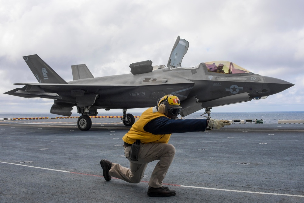 Aviation Boatswain's Mates signal aircraft to take off of the flight deck of amphibious assault ship USS America (LHA 6)