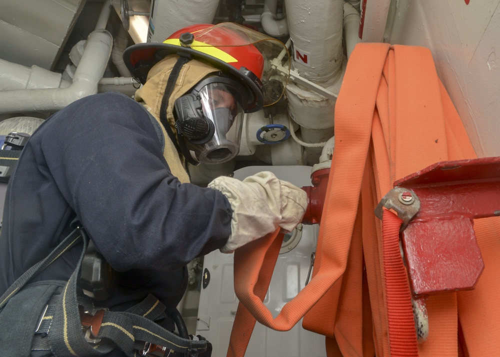 Sailor Restows Fire Hose During General Quarters Drill