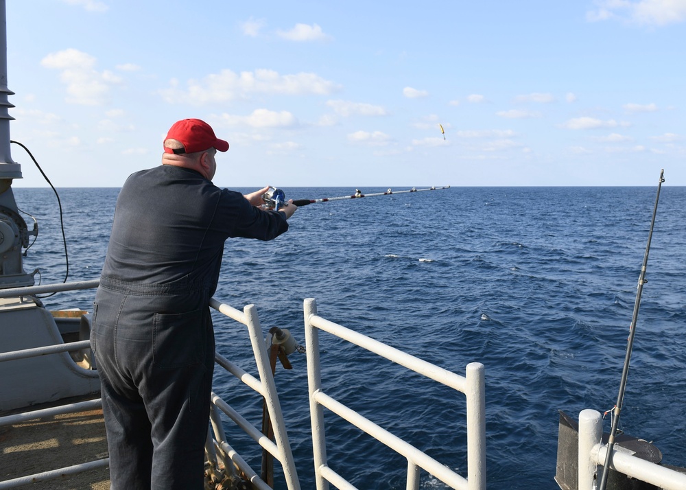 USS Normandy Sailor Fishes During Holiday Routine