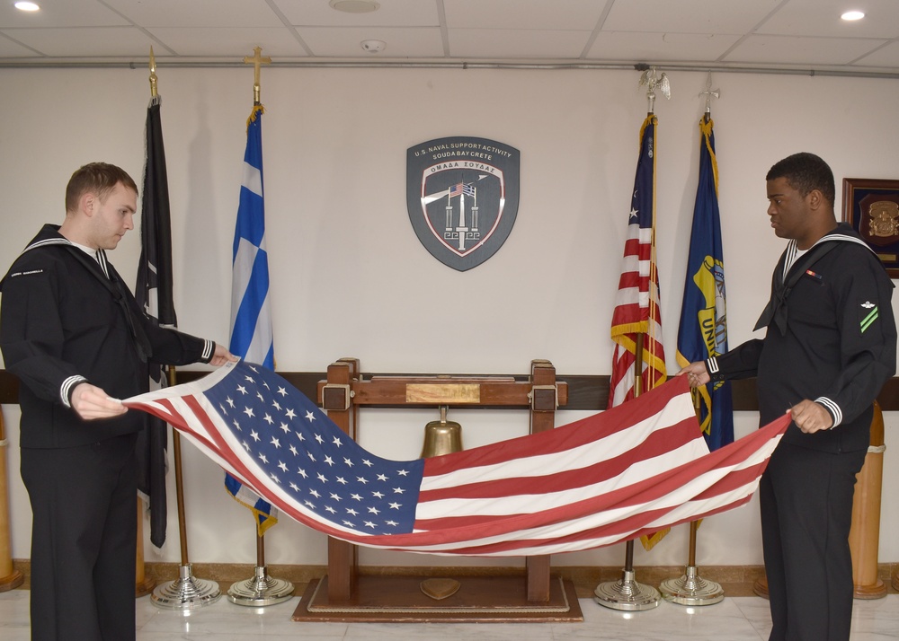 NSA Sailors fold flag after evening colors