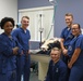 The Navy Medical Readiness and Training Command Pearl Harbor Dental Team stands with dog prepared for dental cleaning and root canal