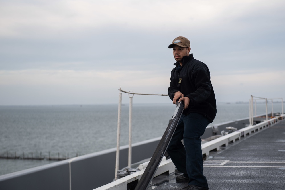 U.S. Sailor prepares for maintenance on the flight deck