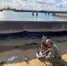 U.S. Navy Seabees with NMCB-5 repair a seawall on board White Beach Naval Facility