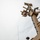 CBP Support to Super Bowl LIV The image shows a military or security surveillance mast mounted on a structure, photographed from a low angle looking upward. The mast is painted in a tan/desert camouflage color and is equipped with multiple sensor systems including an electro-optical/infrared (EO/IR) ball camera, additional cameras, and what appears to be communications or detection equipment. The overcast sky provides a neutral background, emphasizing the technical complexity of the mounted equipment.
