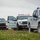 CBP Support to Super Bowl LIV Three law enforcement pickup trucks are parked in a grassy field under an overcast sky. The center vehicle is clearly marked as a U.S. Customs and Border Protection 'Mobile Command' unit with the motto 'Honor First.' All vehicles have emergency lights activated, suggesting an active law enforcement operation.